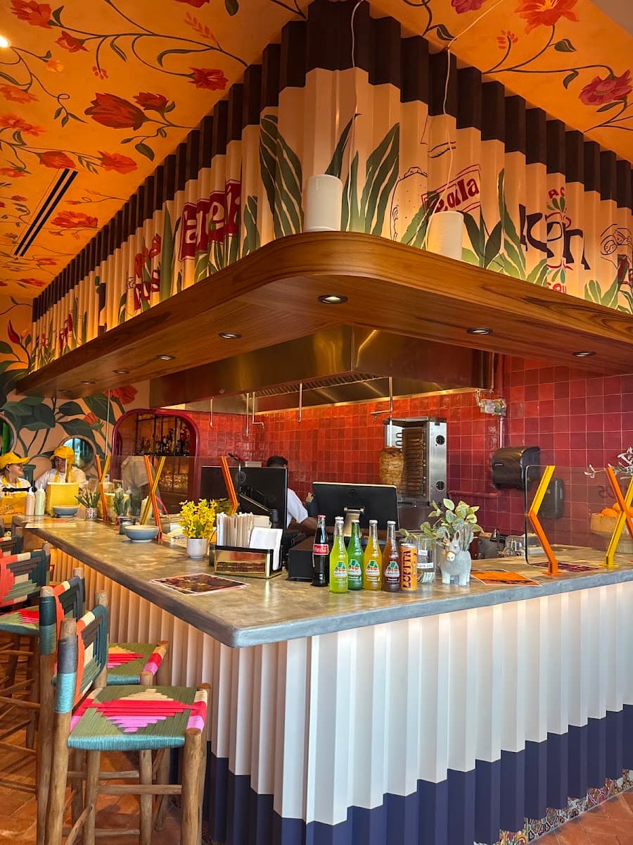 Colorful hand-painted interior of Lupita Tacos y Tequila, with a tiled bar and warm lighting