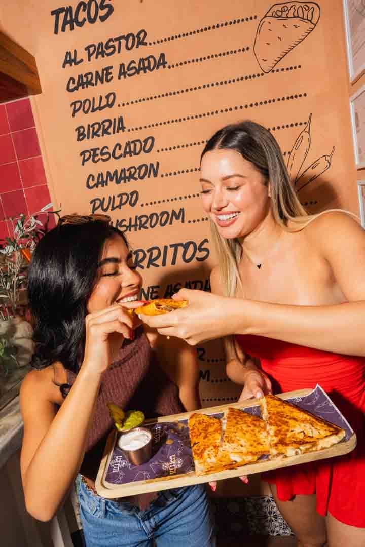 The hand-lettered taco menu wall and a tray of quesadillas at Lupita