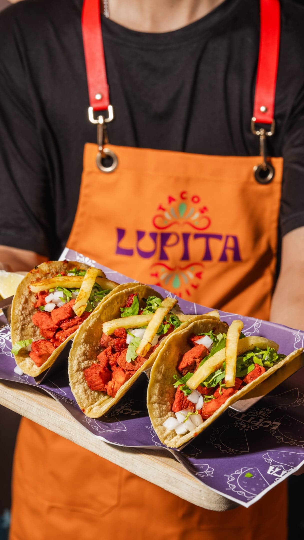 Tacos held up on a Lupita-branded serving tray